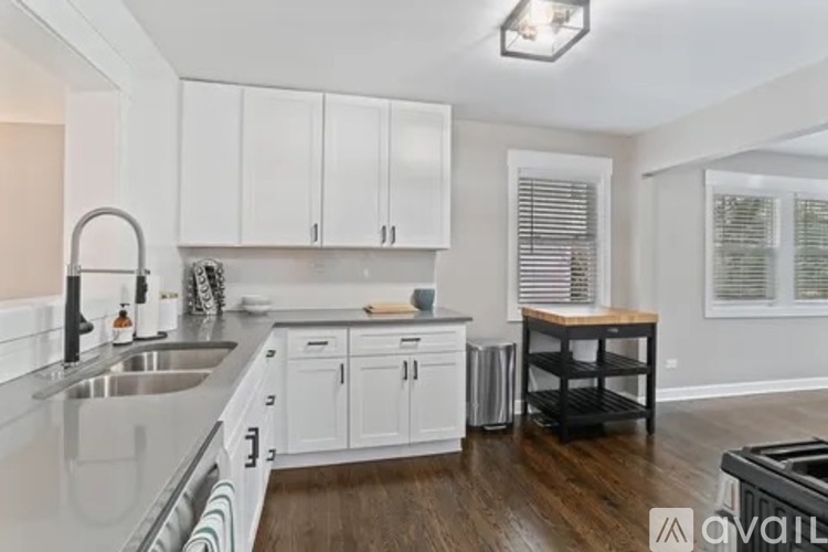 A kitchen with white cabinets and a wooden island.