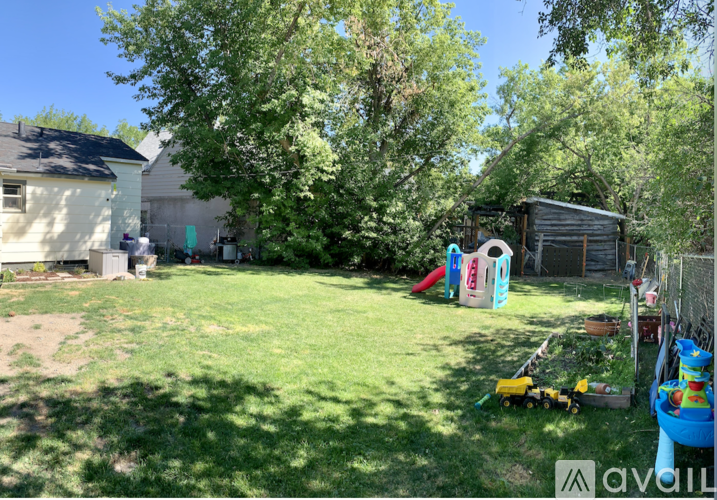 A backyard with a playground and a shed.