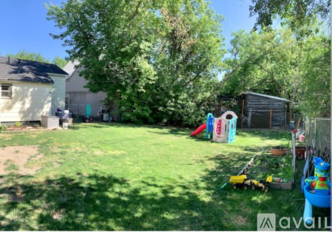 A backyard with a playground and a shed.