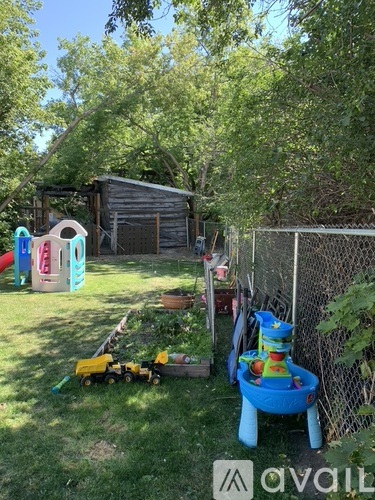 A backyard with a blue wagon and a play structure.