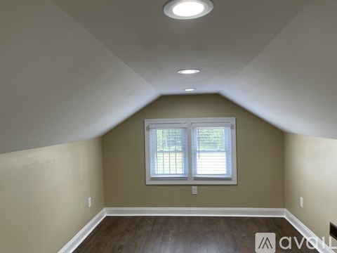 A room with a window and wooden floors.