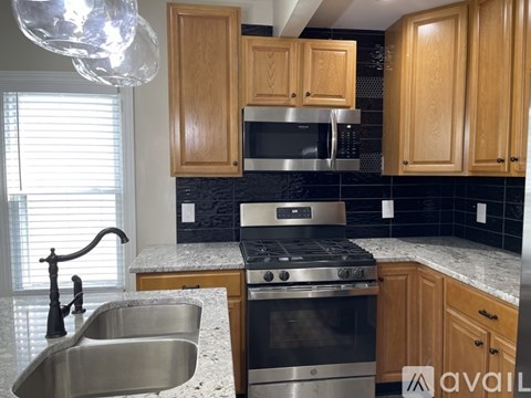 A kitchen with wooden cabinets and a stainless steel oven.