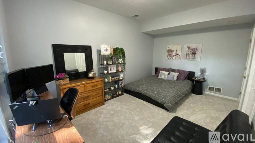 A bedroom with a bed, desk, and chair.