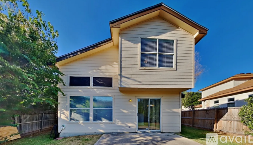 A two-story house with a beige exterior and a brown roof.