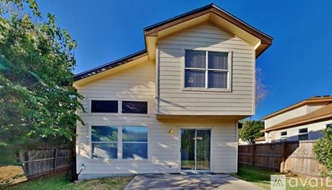 A two-story house with a beige exterior and a brown roof.