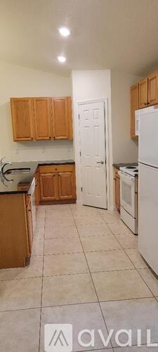 A kitchen with wooden cabinets and a white refrigerator.