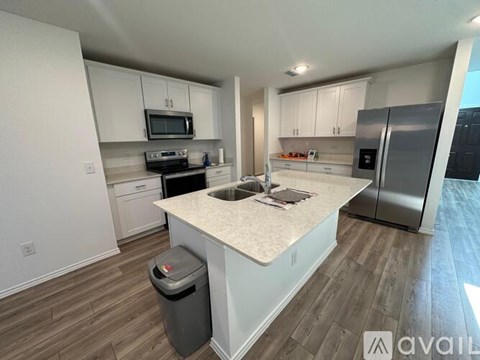 A kitchen with white cabinets and a marble countertop.