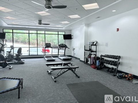 A gym with a variety of equipment including weights and a bench.