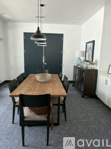 A dining room with a wooden table and chairs.