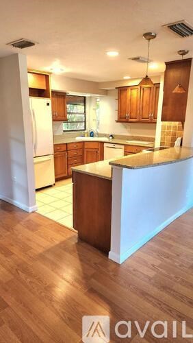 A kitchen with wooden floors and cabinets.