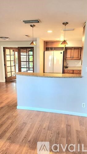 A kitchen with wooden floors and a white counter.