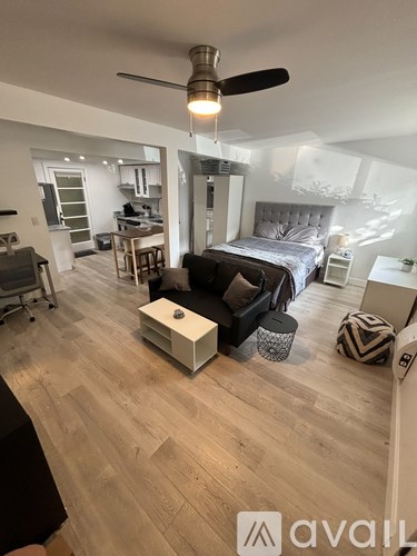 A bedroom with a bed, a chair, and a ceiling fan.