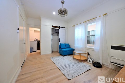A living room with a blue sofa and a rug.