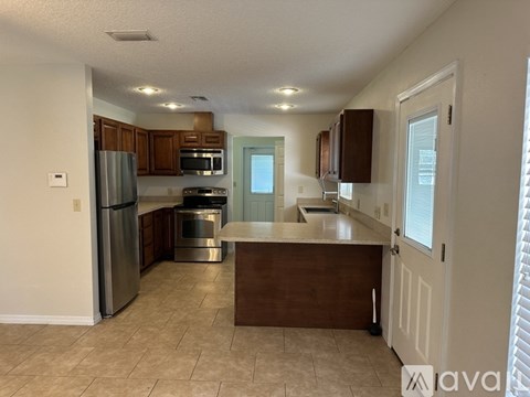 A kitchen with a refrigerator, oven, and microwave.