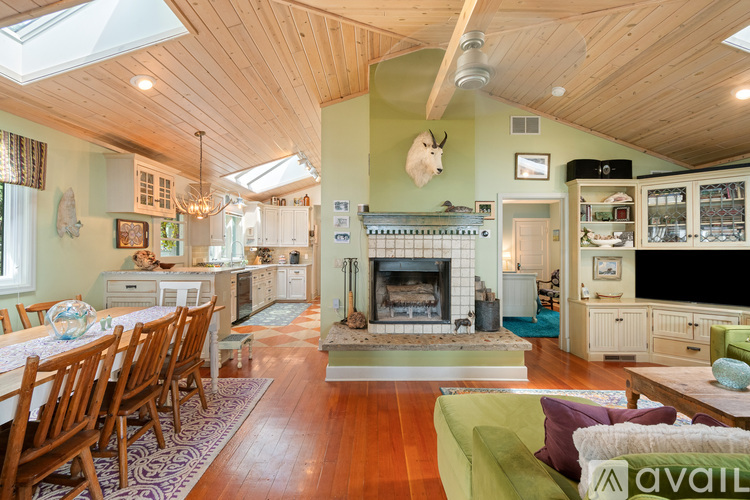 A living room with a fireplace and a dining table.