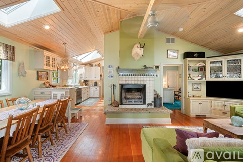 A living room with a fireplace and a dining table.