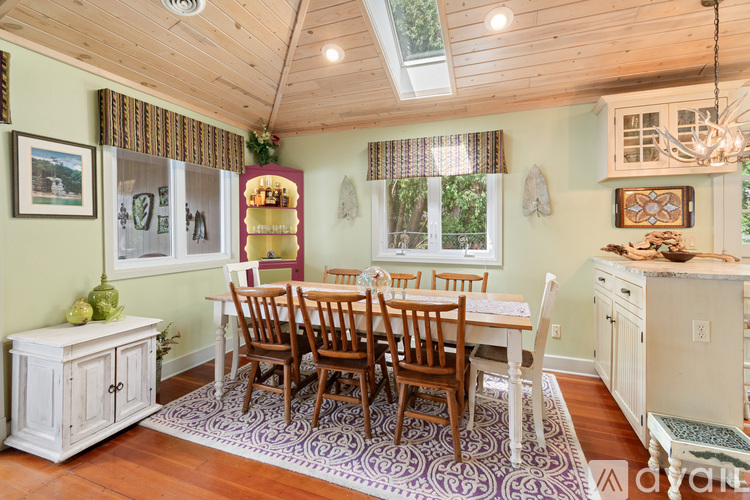 A dining room with a wooden table and chairs.