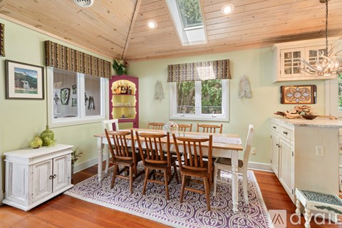 A dining room with a wooden table and chairs.