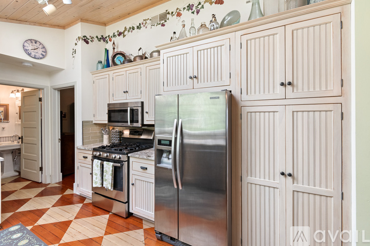 A kitchen with a checkered floor and a refrigerator.