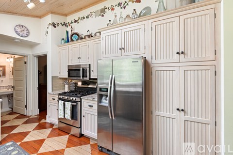 A kitchen with a checkered floor and a refrigerator.