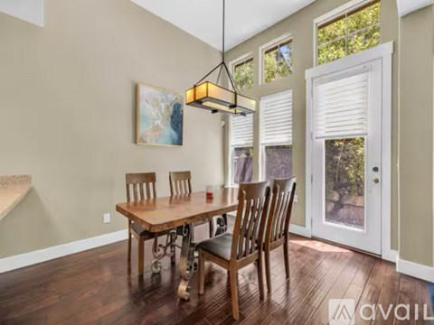 A dining room with a wooden table and chairs.