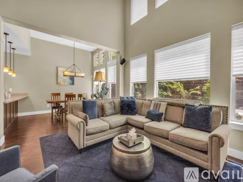 A living room with a large sectional sofa and a coffee table in the center.