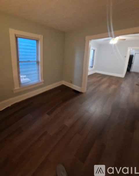 A room with wooden flooring and a window.