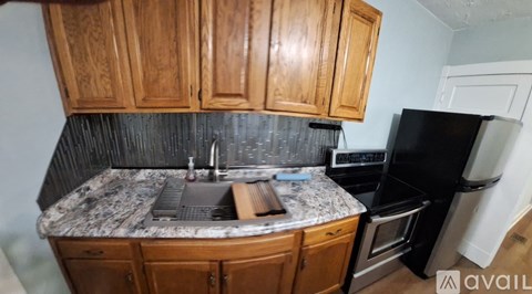 A kitchen with wooden cabinets and black appliances.