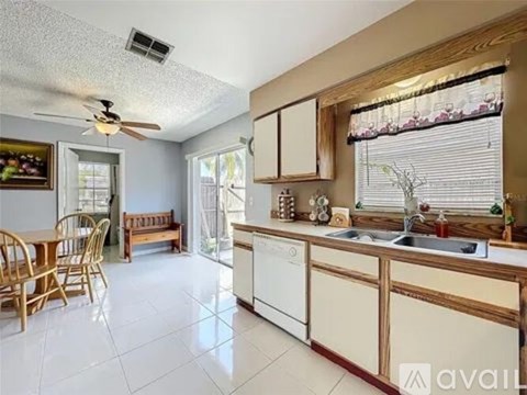 A kitchen with wooden cabinets and a white tile floor.