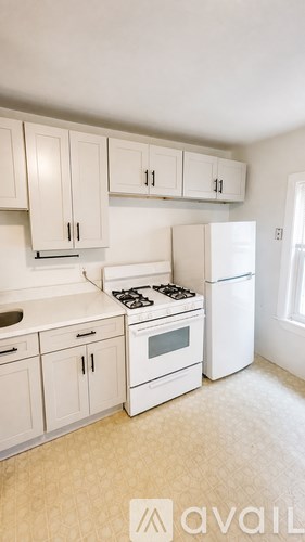 A kitchen with white appliances and cabinets.