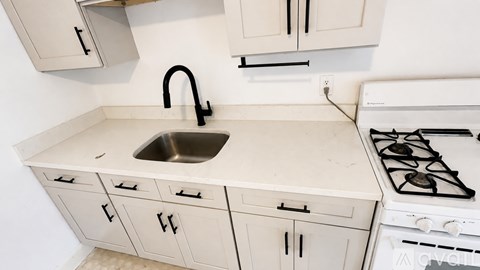 A kitchen with a white stove and a sink.