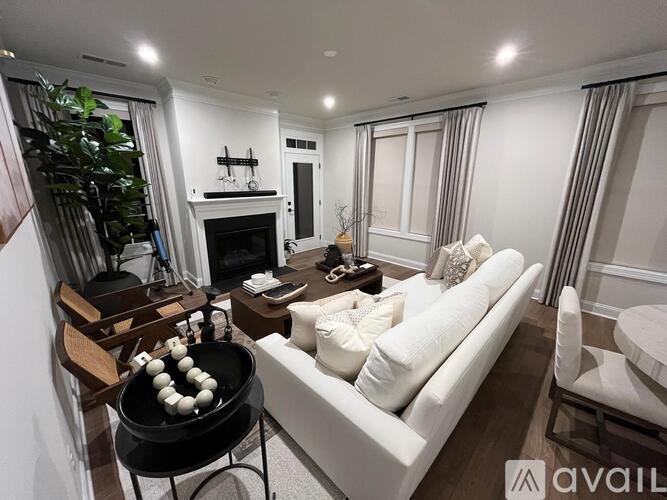 A modern living room with a white sofa and a black grill.