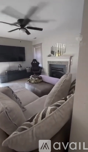 A living room with a couch, a television, and a fireplace.