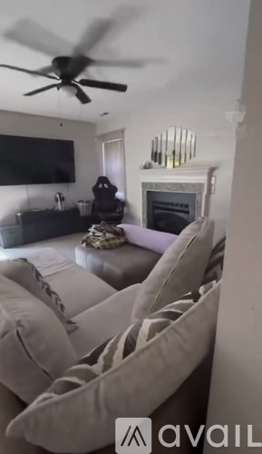 A living room with a couch, a television, and a fireplace.