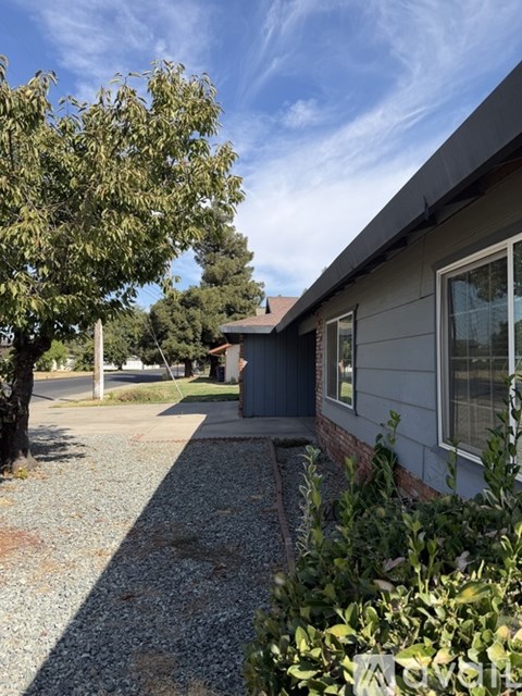 A house with a grey exterior and a gravel driveway.