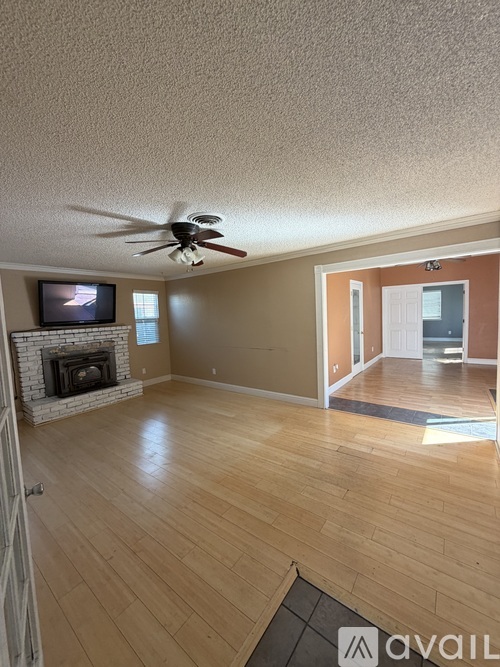 A living room with a fireplace and a television on the wall.