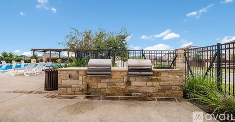A pool area with a diving board and a fence.
