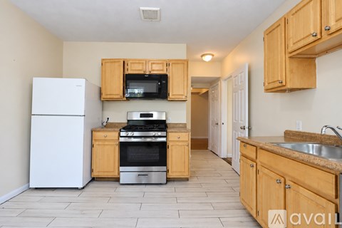 A kitchen with wooden cabinets and a white refrigerator.