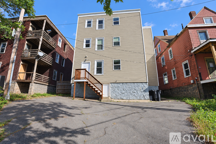 A building with a beige facade is in the middle of a paved lot.