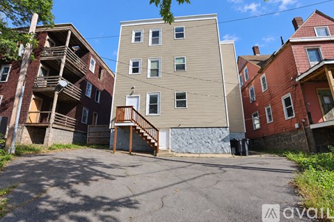A building with a beige facade is in the middle of a paved lot.