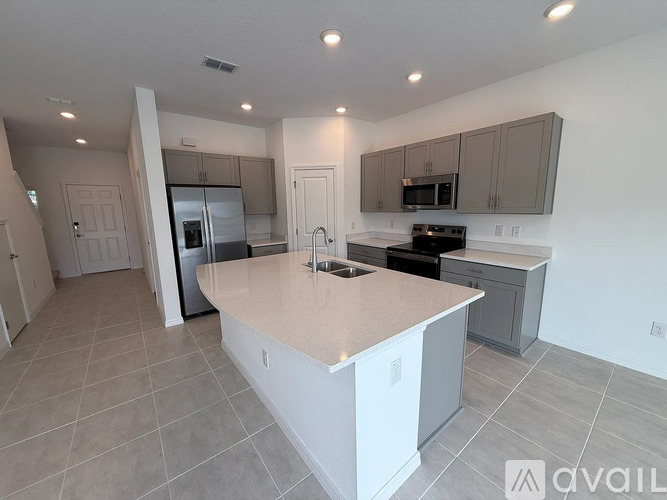 A kitchen with a white island in the middle of the room.