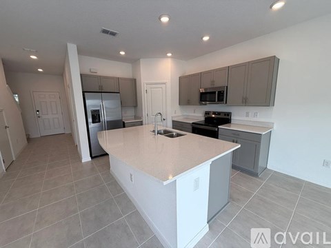 A kitchen with a white island in the middle of the room.