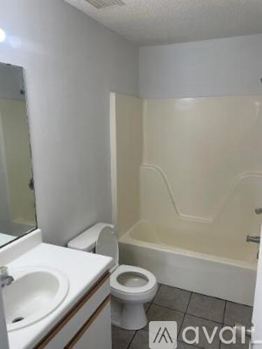 A bathroom with a toilet, sink, and bathtub.
