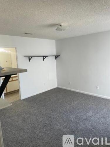 A room with grey carpet and white walls.