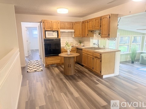 A kitchen with wooden cabinets and a black fridge.