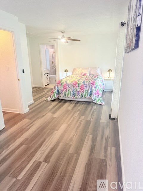 A bedroom with a bed covered in a floral print bedspread.