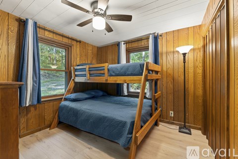 A bedroom with a bunk bed and a ceiling fan.