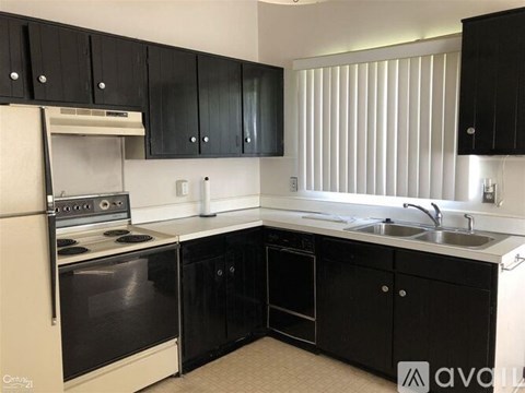 A kitchen with black cabinets and a white oven.