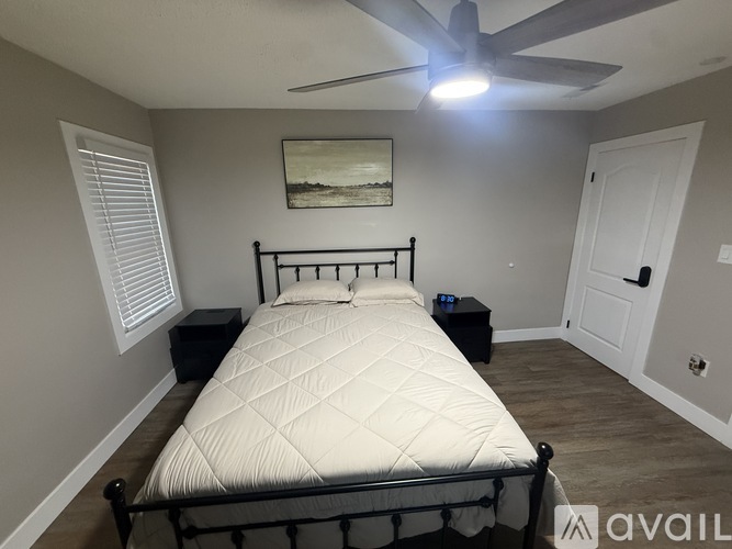 A bedroom with a large bed and a ceiling fan.