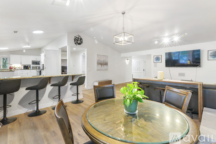 A modern dining room with a glass table and chairs.